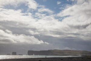 Vista del promontorio Dýrhólaey dalla spiaggia di Reynisfjara