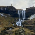 Una persona in cima alla cascata Selvallafoss